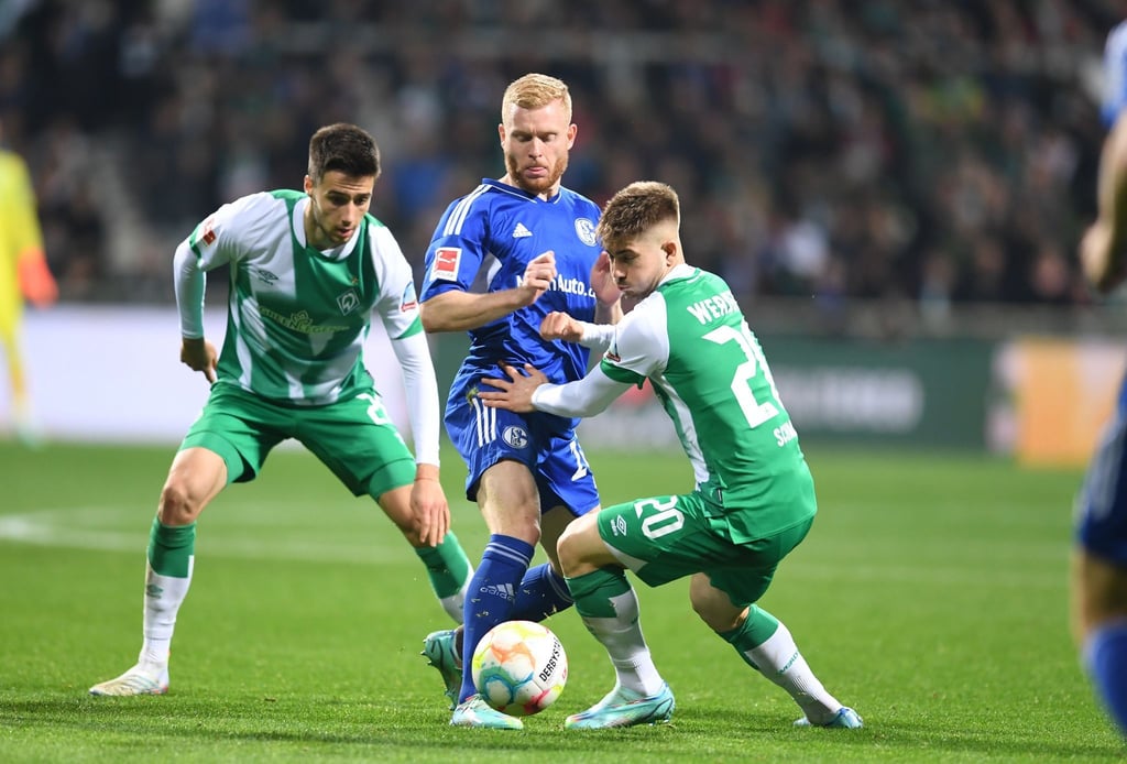 Werders Romano Schmid (r) und Ilia Gruev (l) kämpfen gegen Schalkes Florent Mollet um den Ball.