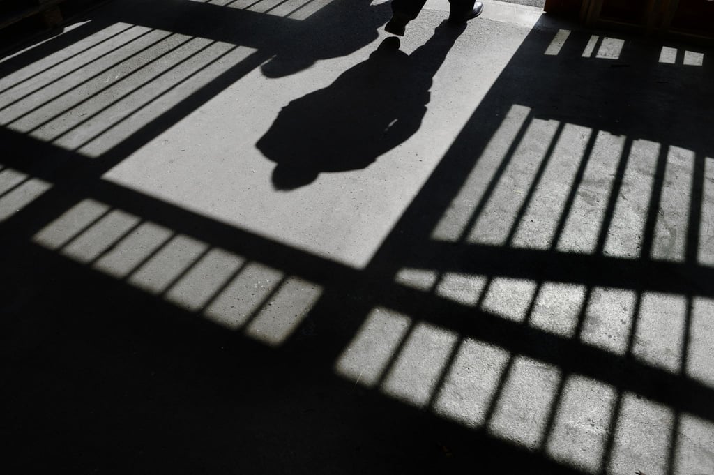 Der Schattenriss eines Mannes ist in der Justizvollzugsanstalt in einer Tür zu sehen.