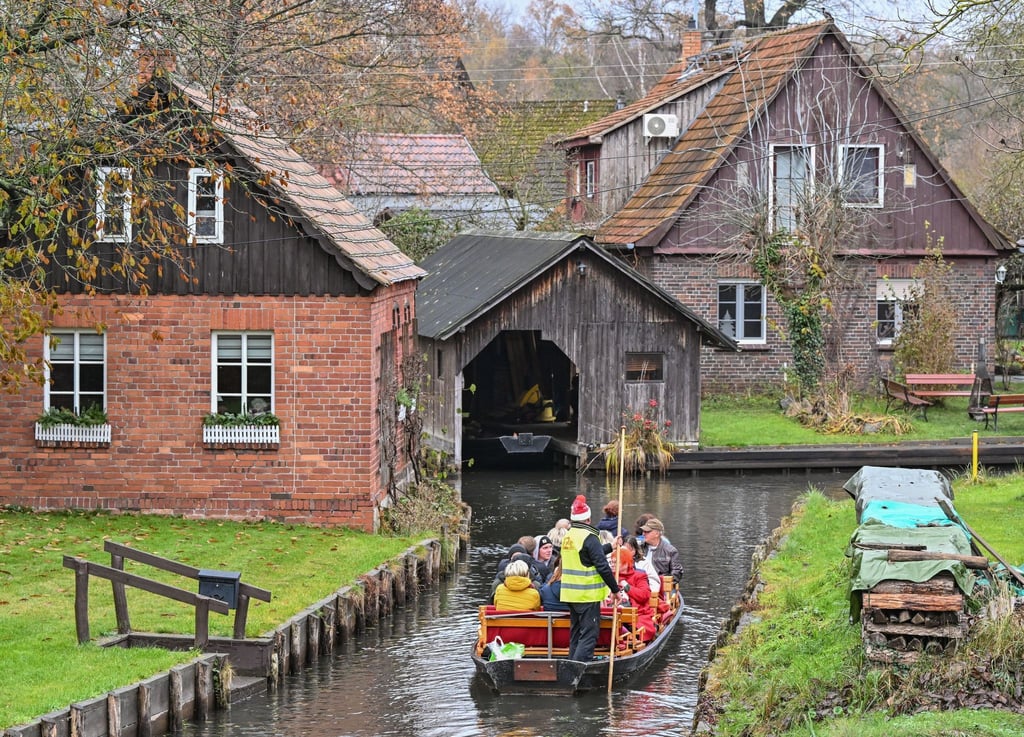 Mit einem Kahn sind Besucher zum Weihnachtsmarkt im Freilandmuseum des Spreewaldorfs Lehde unterwegs.