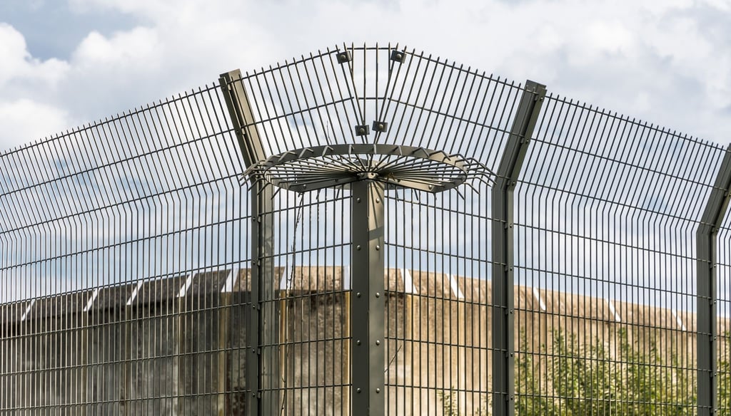 Eine Mauer und ein Drahtzaun eines Gefängnisses.