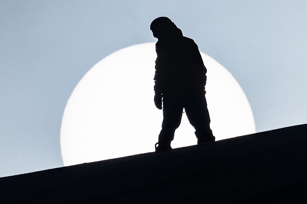 Ein Snowboarder fährt am Matthias-Schmidt-Berg im Harz an der Sonne vorbei.