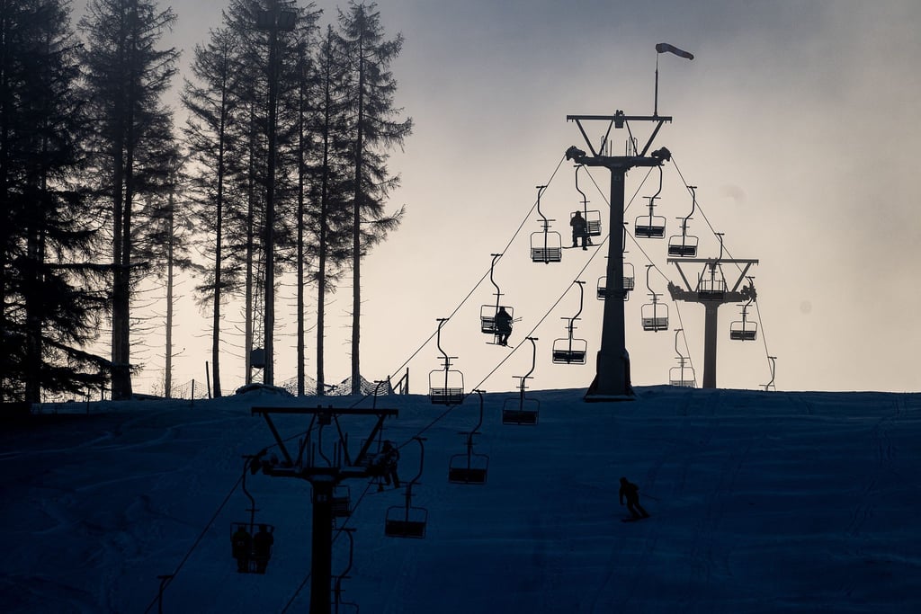 Wintersportler sitzen am Matthias-Schmidt-Berg im Harz in der Seilbahn.