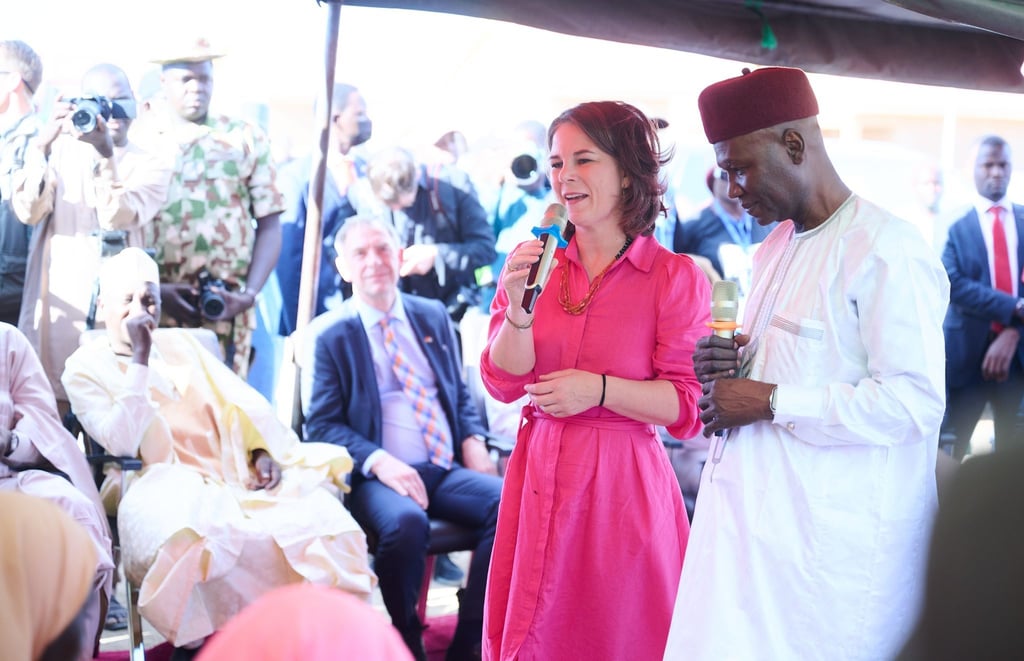 Bundesaußenministerin Annalena Baerbock spricht in Ngarannam, das 2015 von Boko Haram fast ganz zerstört und wieder aufgebaut wurde, mit Bewohnerinnen und Bewohnern.