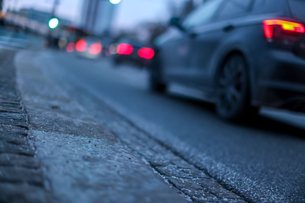 Autos fahren am Morgen bei einsetzendem Regen über den Leipziger Ring.