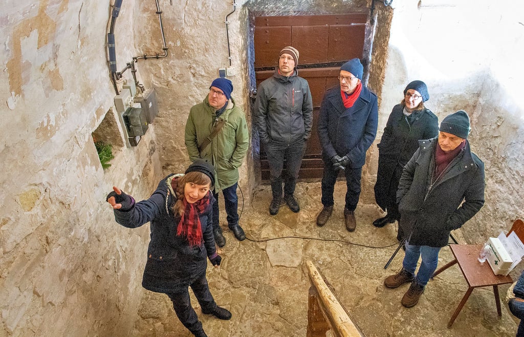 Restauratorin Marie Fortmann (l.) erklärt im Eingangsbereich der Kirche Schleberoda die mittelalterlichen Wandmalereien.