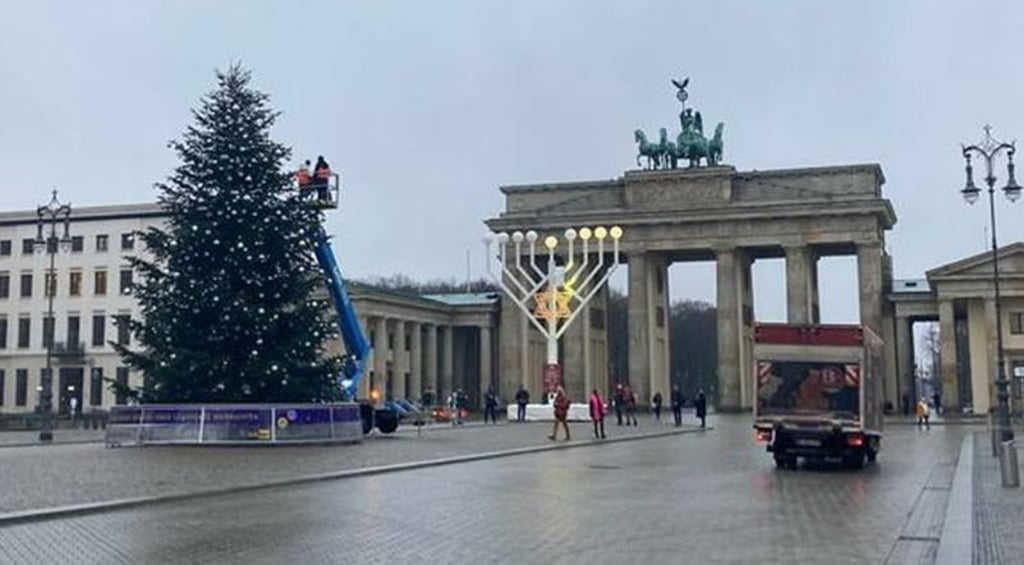 Zwei Frauen sägen zwei Meter der Spitze einer nahezu perfekt gewachsenen Thüringer Nordmanntanne am Brandenburger Tor auf dem Pariser Platz in Berlin ab. Sie gehören den Umweltaktivisten der sogenannten Letzten Generation an. Foto: