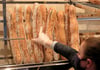 Ein Verkäuferin nimmt ein Baguette aus dem Regal einer Bäckerei.