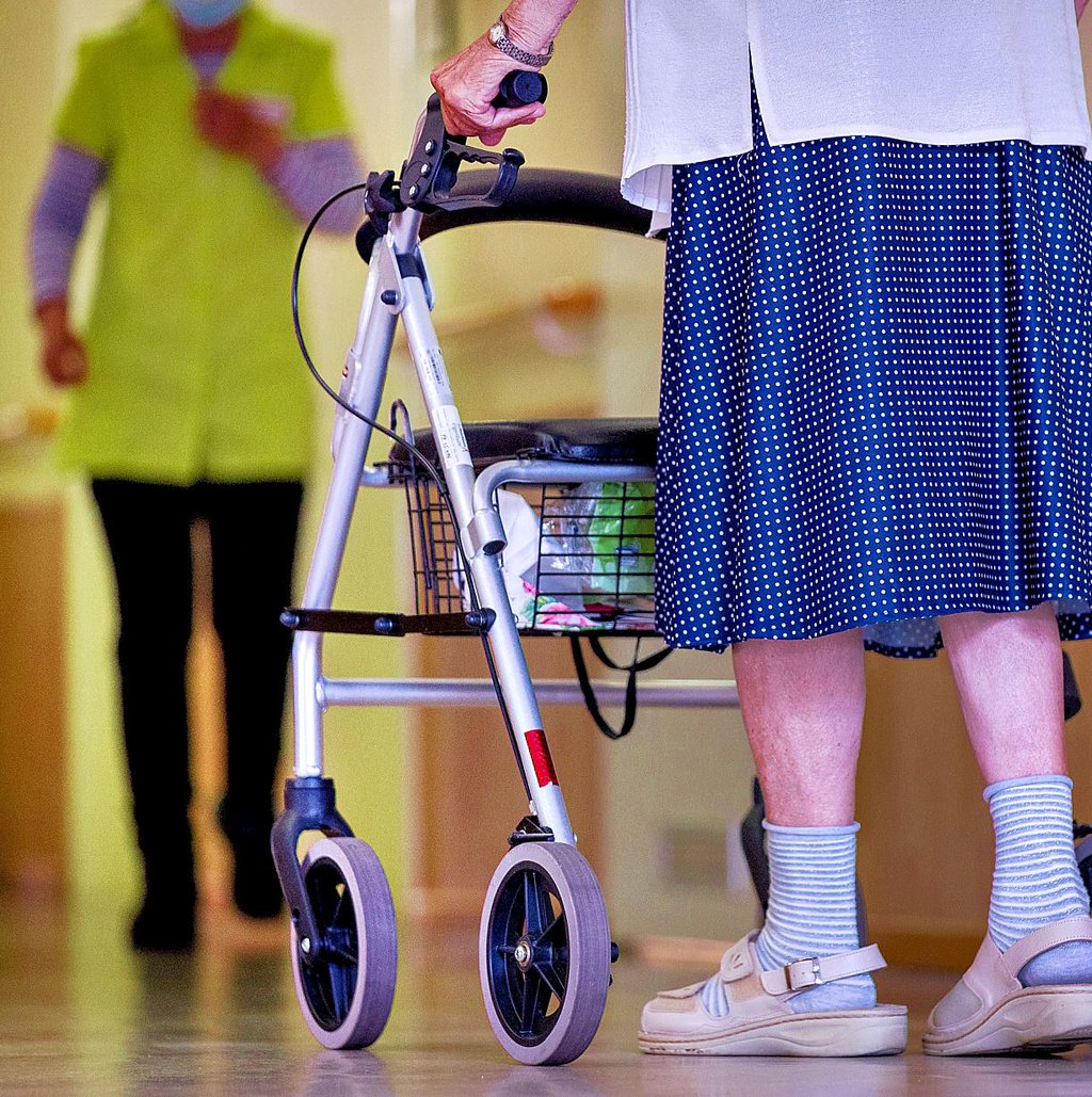Eine ältere Dame geht mit ihrem Rollator über einen Flur der Wohnrichtung. Bewohner von Pflegeheimen in Sachsen-Anhalt müssen teils deutlich steigende Kosten für ihren Platz tragen.