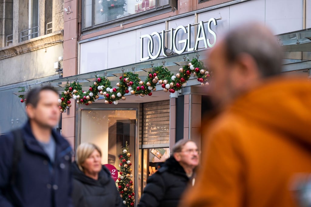 Passanten gehen in der Innenstadt von Dortmund: Douglas macht gute Geschäfte.