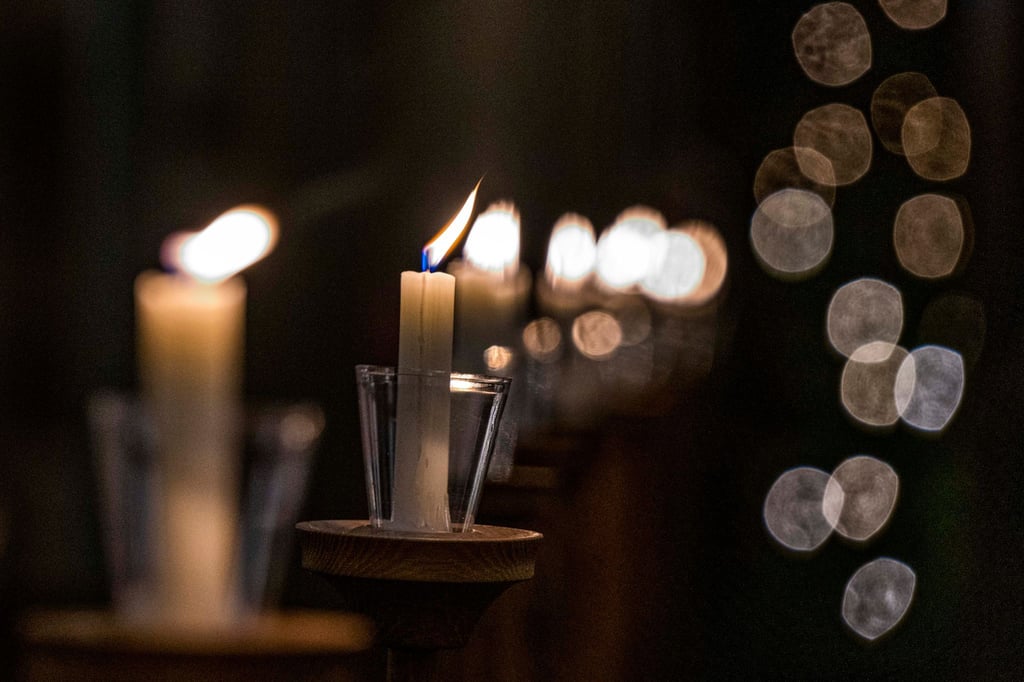 Kerzen leuchten in einer Kirche.