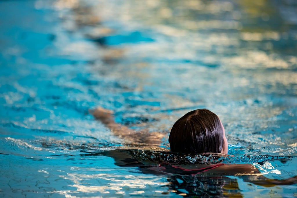 Ein Kind schwimmt in einem Schwimmbad.