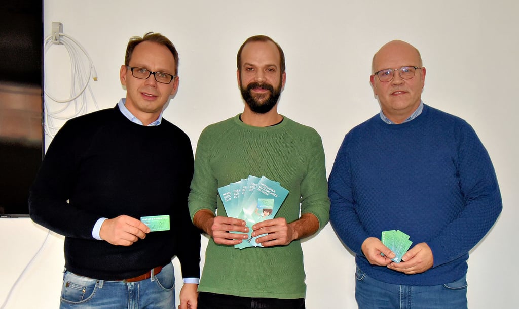 Der Geschäftsführer der Klusstiftung Hendrik Fries, der Vorsitzende der Mitarbeitervertretung Slobodan Stricevic sowie das stellvertretende Vorstandsmitglied der Salzlandsparkasse, Kevin Klausnitzer (von rechts), präsentieren die Salzlandkarte.