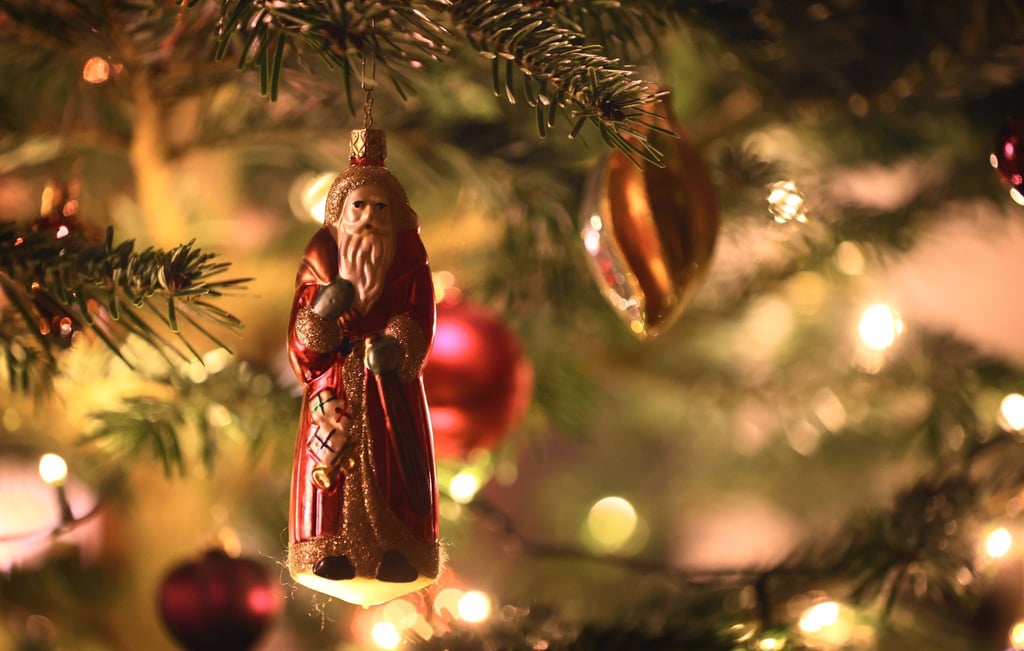 Weihnachtsschmuck hängt an einem Tannenbaum.