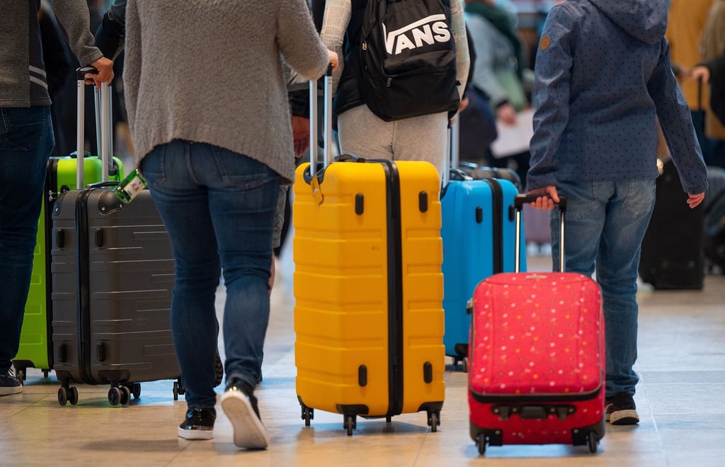 Fluggäste schieben ihre Rollkoffer durch den Abflugbereich im Terminal 1 des Flughafens BER.