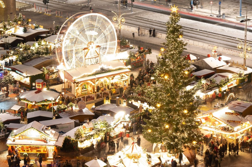 Ein Riesenrad dreht sich neben mit Schnee bedeckten Verkaufsständen auf dem Striezelmarkt (Aufnahme mit Langzeitbelichtung).
