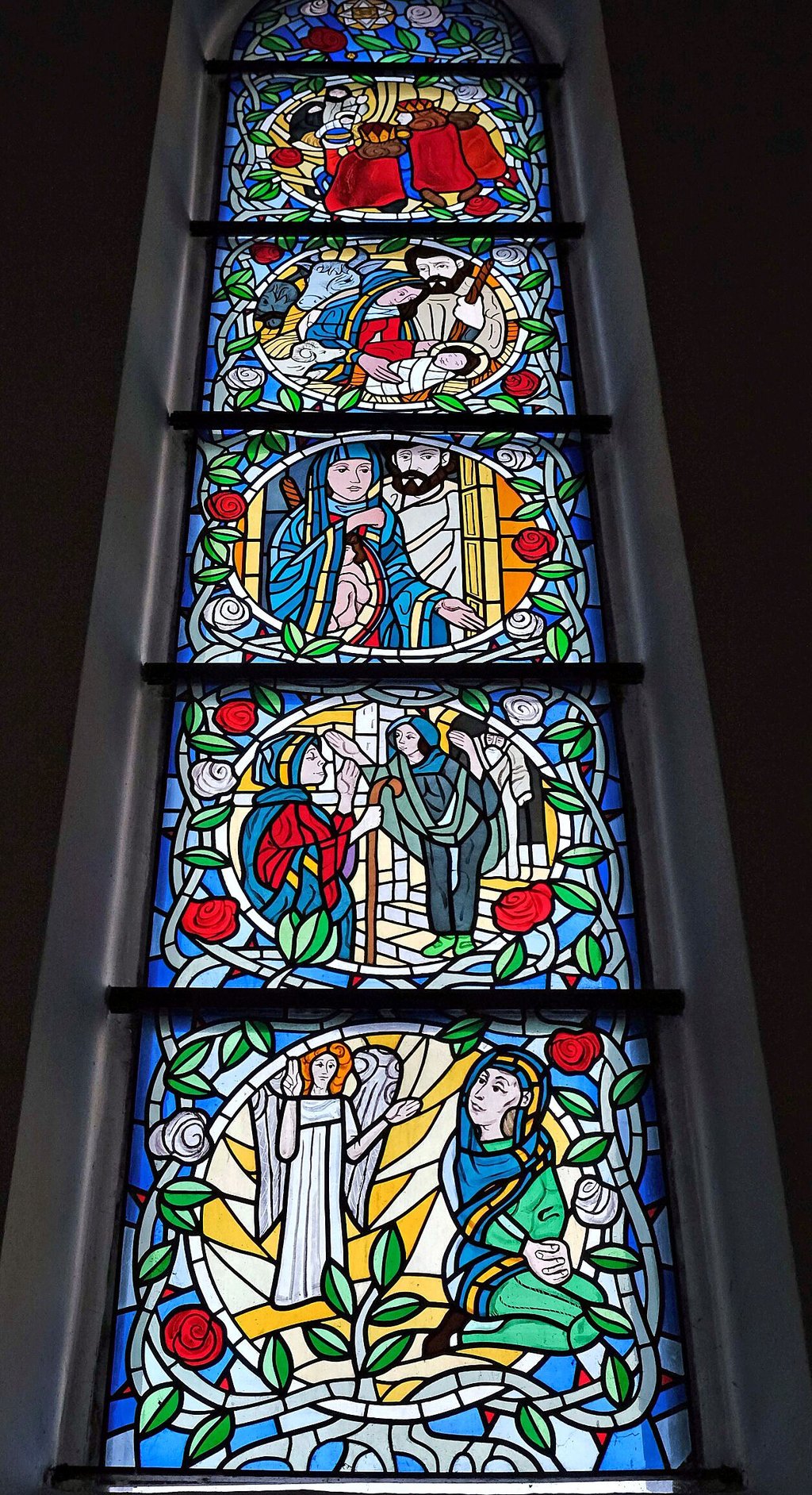 In fünf Szenen zeigt das Glasfenster die Weihnachtsgeschichte: von der Verkündigung des Engels bis zur Anbetung durch die drei Könige.