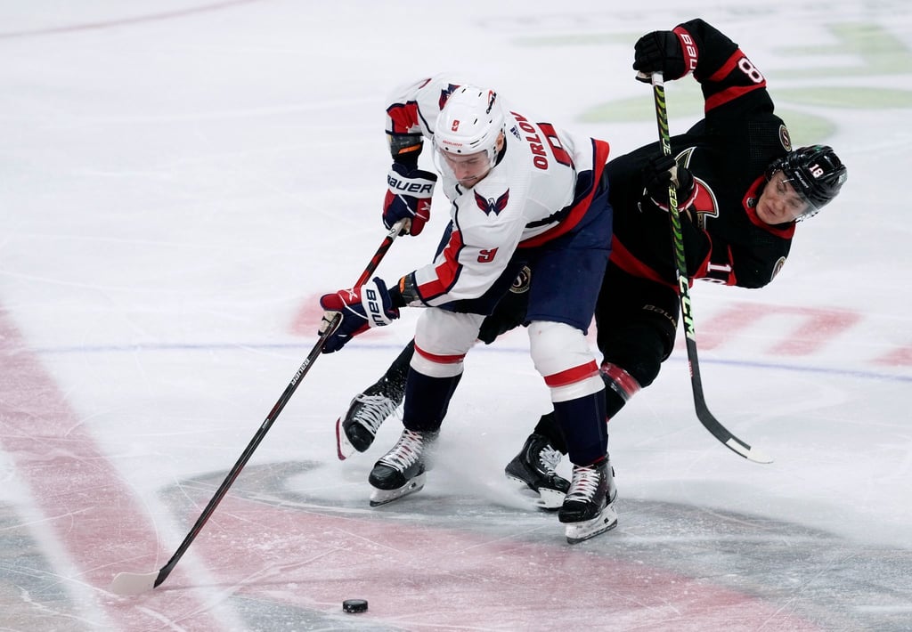Der Verteidiger der Washington Capitals, Dmitry Orlov (l), wehrt sich gegen den linken Flügel der Ottawa Senators, Tim Stützle.
