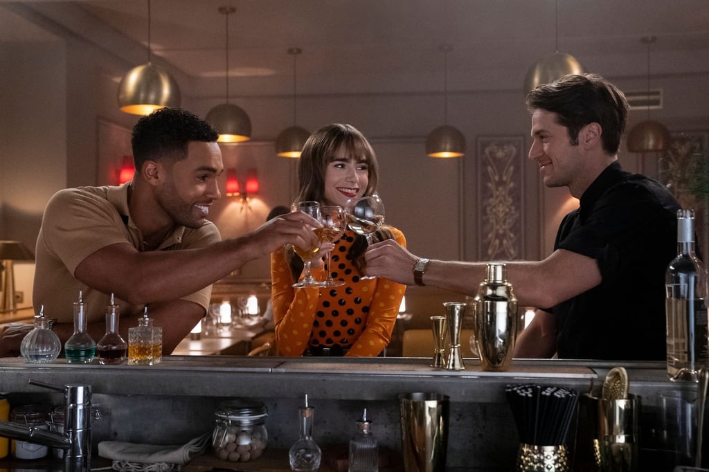 Lucien Laviscount (l) als Alfie, Lily Collins als Emily und Lucas Bravo als Gabriel in der dritten Staffel der Serie "Emily in Paris".