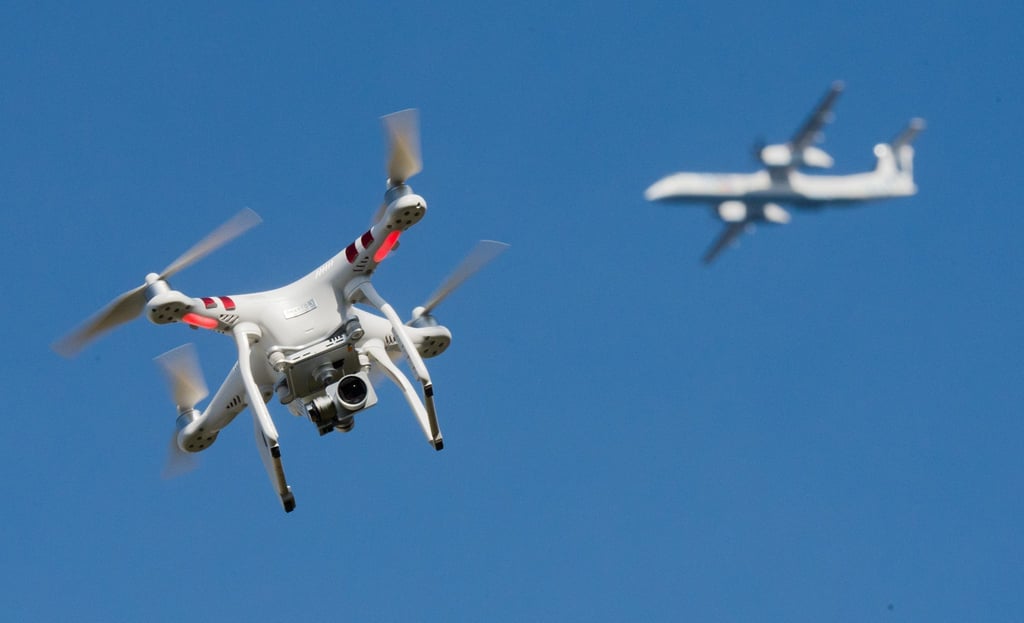 Eine private Drohne fliegt weit entfernt von einem Flugzeug.