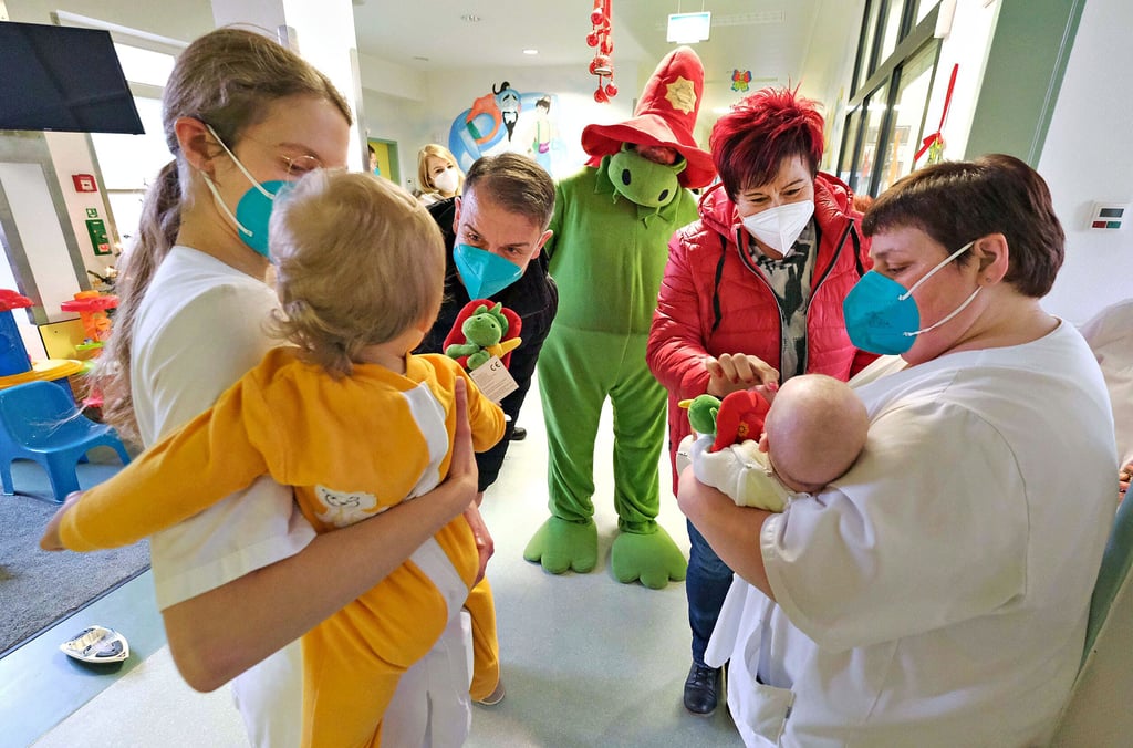 Mitglieder des Feuerwehrvereins mit Maskottchen Grisu überreichen zum Fest Geschenke auf der Kinderstation des Gesundheitszentrums Bitterfeld/Wolfen.