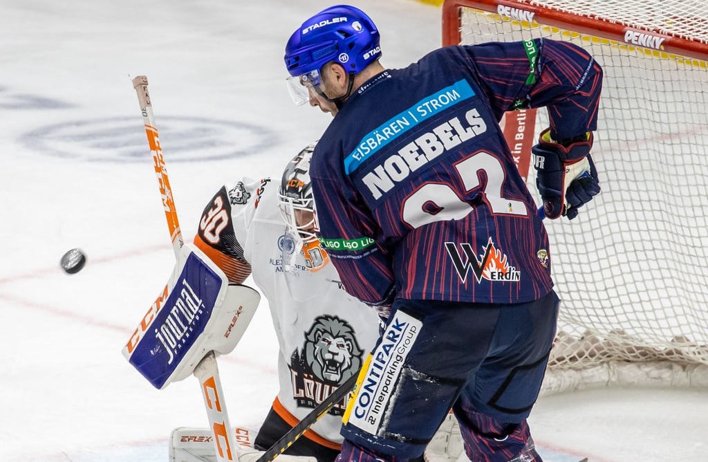 Ein Torhüter kämpft gegen Berlins Marcel Noebels (r) um den Puck.