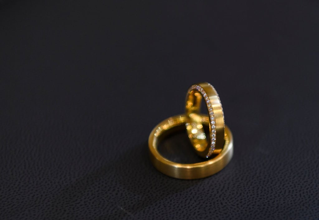 Trauringe auf schwarzem Untergrund. Eine ehrliche Finderin hat eine Schachtel mit zwei Ringen auf der Straße gefunden, sich bei der Polizei gemeldet und damit einen Heiratsantrag an Heiligabend möglich gemacht (Symbolbild).