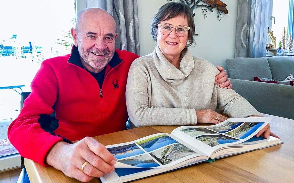 Maria und Gerd Piller blättern in ihrem Reise-Fotobuch.