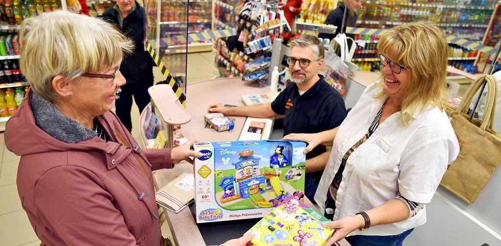 Judith Knopf (von links) tauscht bei Müller-Mitarbeiter Sven Webel und der stellvertretenden Marktleiterin Karola Priewe Spielwaren um.