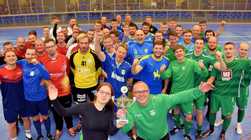 Lia Döring und Tobias Baldzun (vorn) vom gastgebenden Sportverein Grün-Weiß Süplingen präsentieren vor dem Anpfiff der Stadt-Meisterschaft den "Pokal des Bürgermeisters."