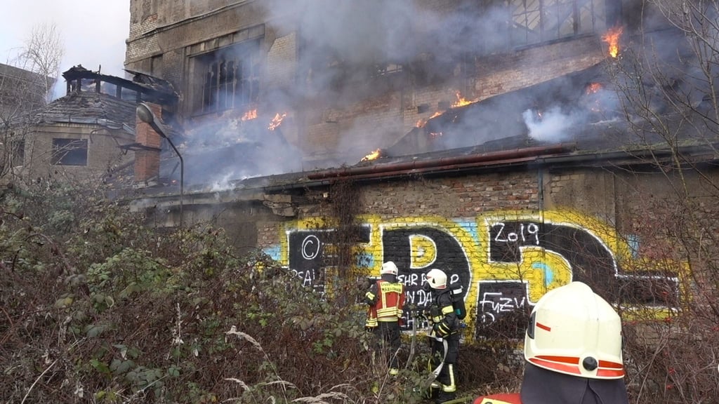 Feuerwehrleute im Einsatz bei einem Brand in ehemaligen Industriegebäude.