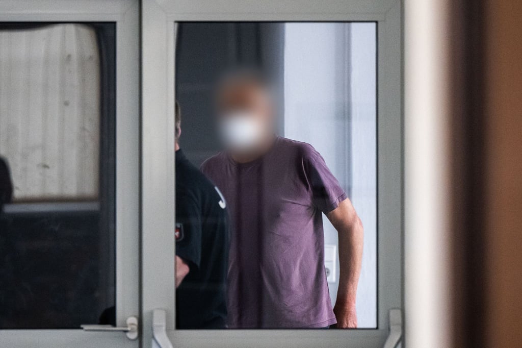 Ein wegen zweifachen Mordes und versuchten Mordes angeklagter Mann wird in den Gerichtssaal geführt.
