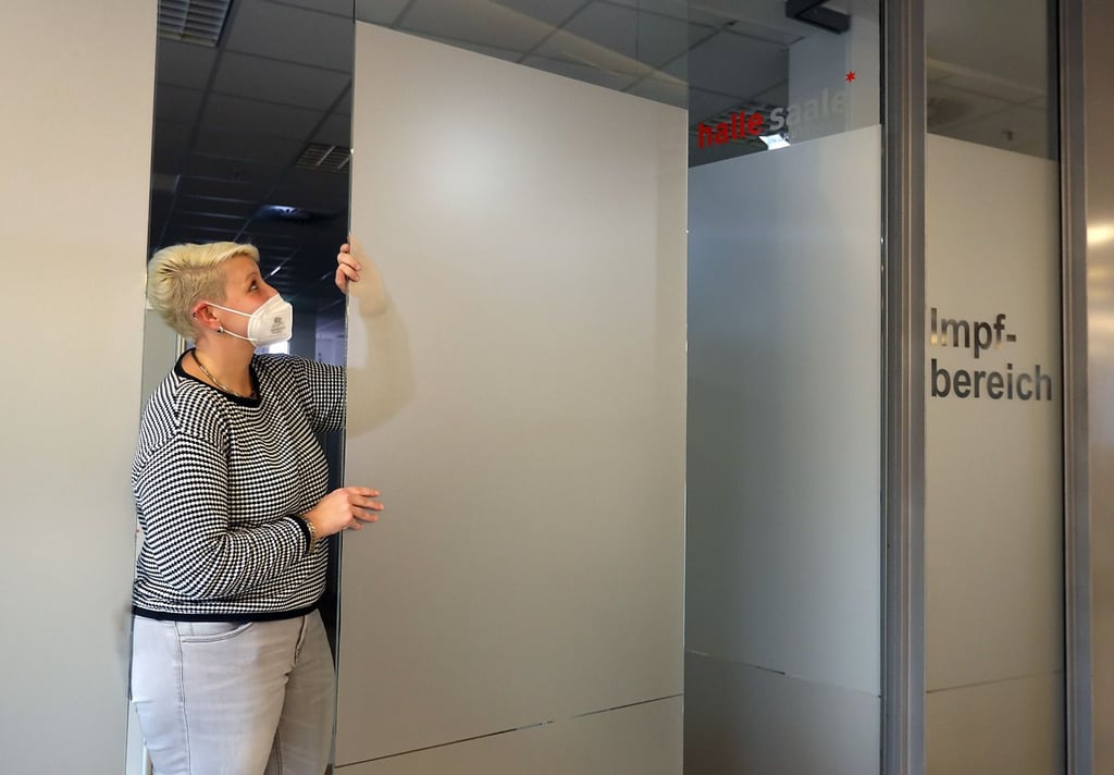 Eine Mitarbeiterin schließt die Glastüren. Das Impfzentrum im Saalecenter von Halle geht vorläufig in den Winterschlaf. Wiedererweckung ungewiss.