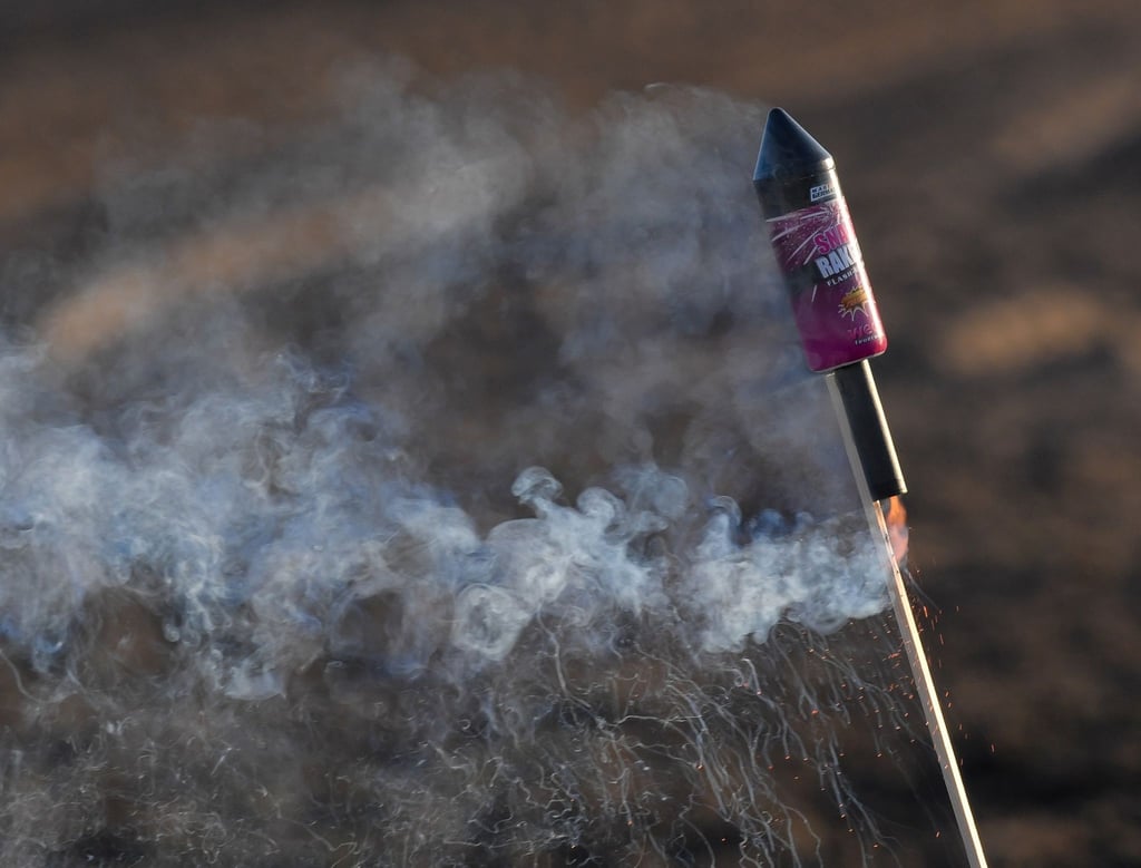 Eine angezündete Silvester-Rakete steckt im Boden.