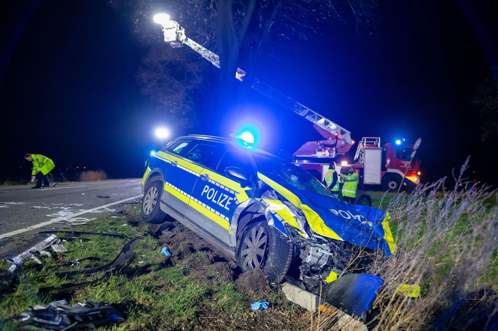 Ein beschädigter Polizeiwagen liegt nach einem Unfall neben einer Bundesstraße.