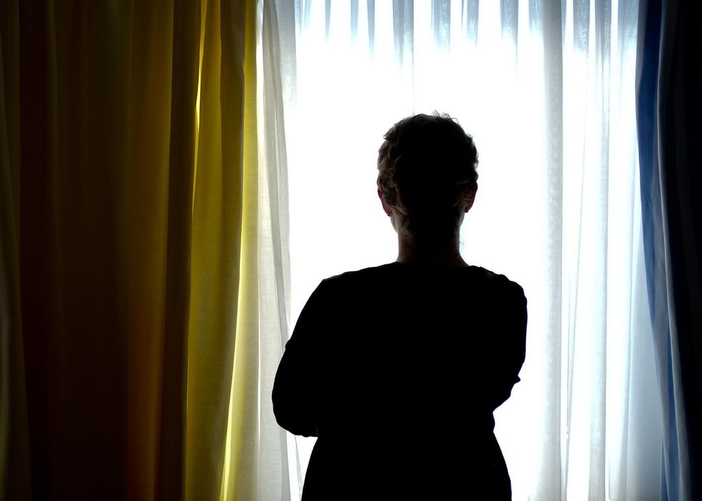 Eine junge Frau steht in einem Zimmer eines Frauenhauses.