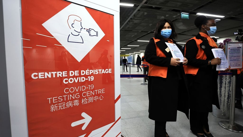 Zwei Flughafenmitarbeiterinnen warten auf dem französischen Flughafen Roissy-Charles de Gaulle auf Passagiere aus China.