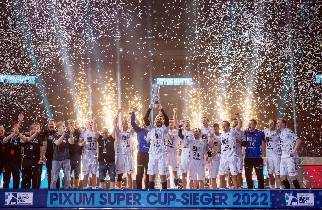 Kiels Spieler jubeln bei der Siegerehrung im Sommer 2022 mit dem Pokal.