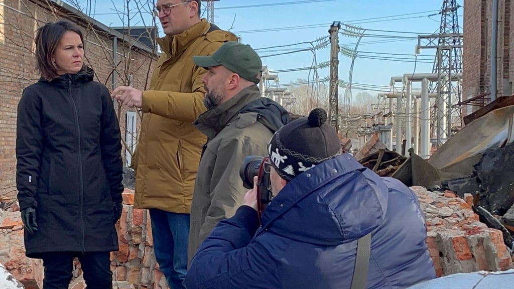 Annalena Baerbock im Gespräch mit dem ukrainischen Außenminister Dmytro Kuleba (3.v.r) in Charkiw auf dem Gelände eines den Russen zerstörten Umspannwerkes.