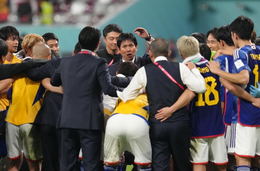 Japans Trainer Hajime Moriyasu (M) spricht nach dem Sieg gegen Spanien zu den Spielern.