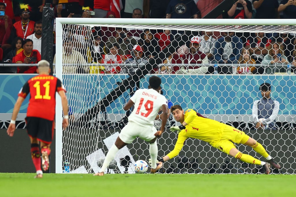 Belgiens Torwart Thibaut Courtois (r) hält den Strafstoß des Kanadiers Alphonso Davies (M/19).