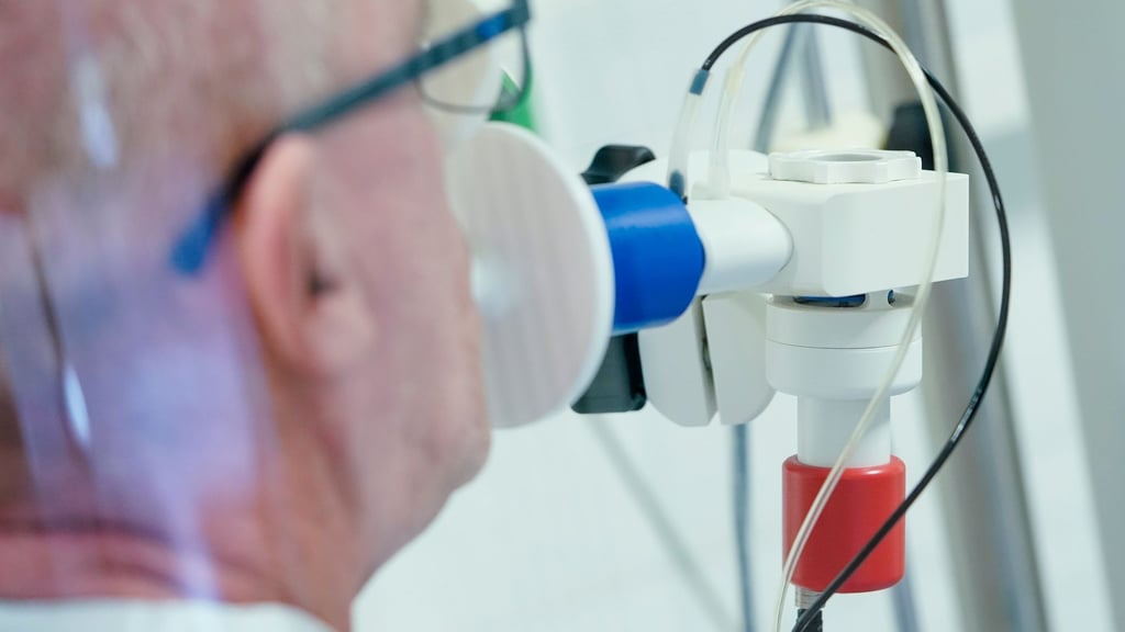 Ein von einer Corona-Erkrankung genesener Patient bekommt in einer Lungentest-Kabine in einer Rehaklinik die Lungenfunktion gemessen.
