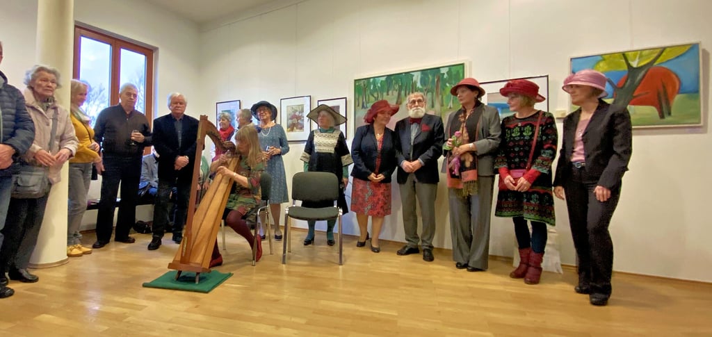Die sechs Dienstagsmalerinnen mit ihrem Mentor Gerhard Kitzig vor ihren Bildern im oberen Foyer des Jessener Schlosses. Dorothea Schulze begleitet die Vernissage auf einer Böhmischen Hakenharve. Links neben ihr Laudator Lothar Günther.