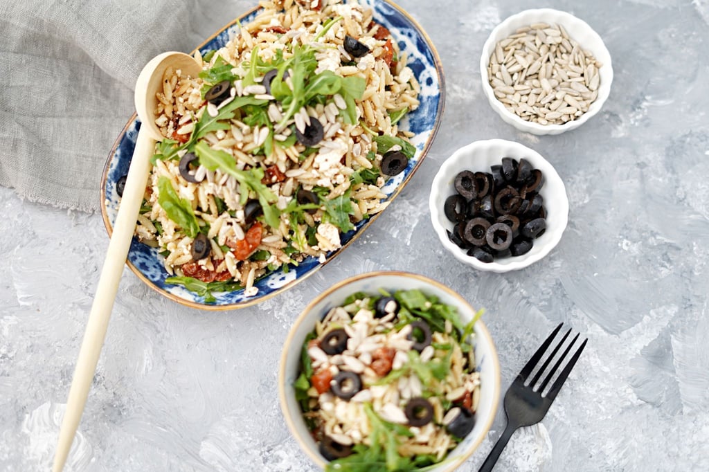 Der bunte griechische Salat mit getrockneten Tomaten, Feta, Oliven, Rucola und den Kritharakinudeln bringt Farbe auf jedes BBQ-Buffet.