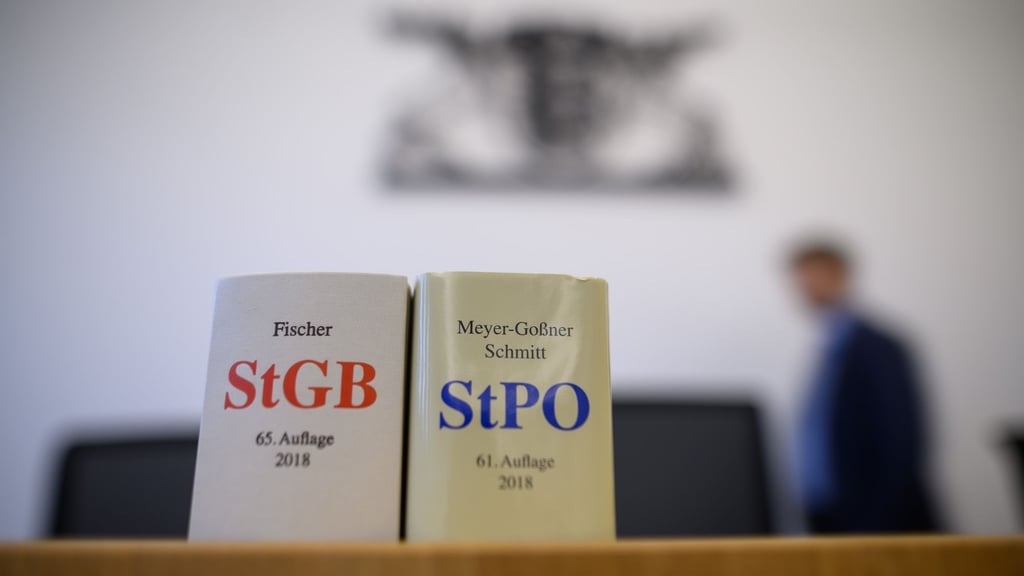 Eine Ausgabe des Strafgesetzbuchs und der Strafprozessordnung stehen in einem Gerichtssaal.