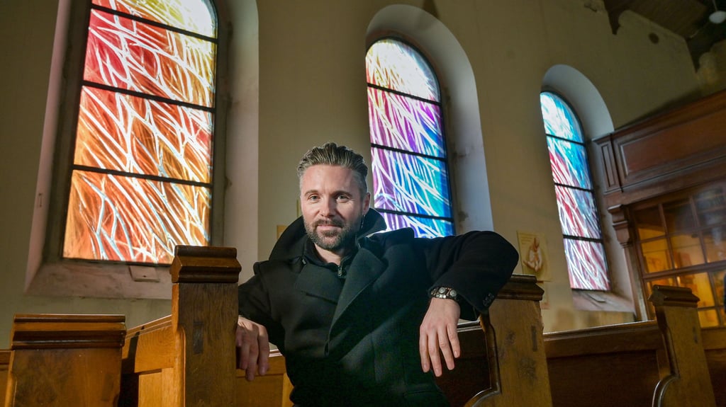 Christian Keinstar in der Kirche von Elsnigk vor den Fenstern, die nach seinen Entwürfen entstanden sind.