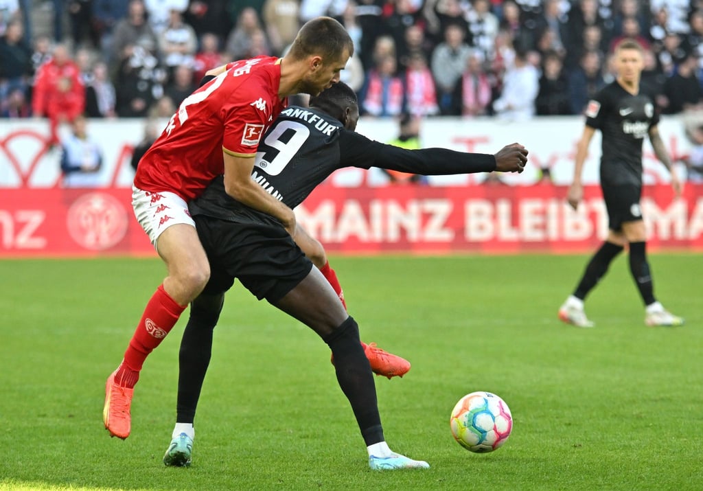 Frankfurts Torschütze Randal Kolo Muani (r) im Zweikampf mit dem Mainzer Alexander Hack.