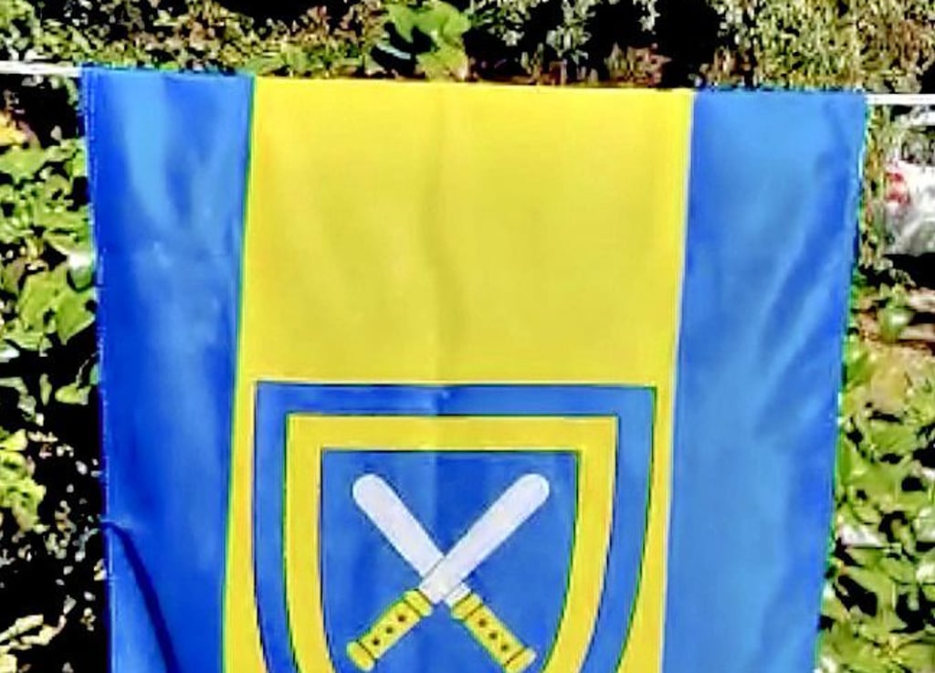 Vor viel Grün weht die Flagge, die an einer Wäscheleine hängt. Sie muss für die Animation auf jedem Einzelbild freigestellt werden.