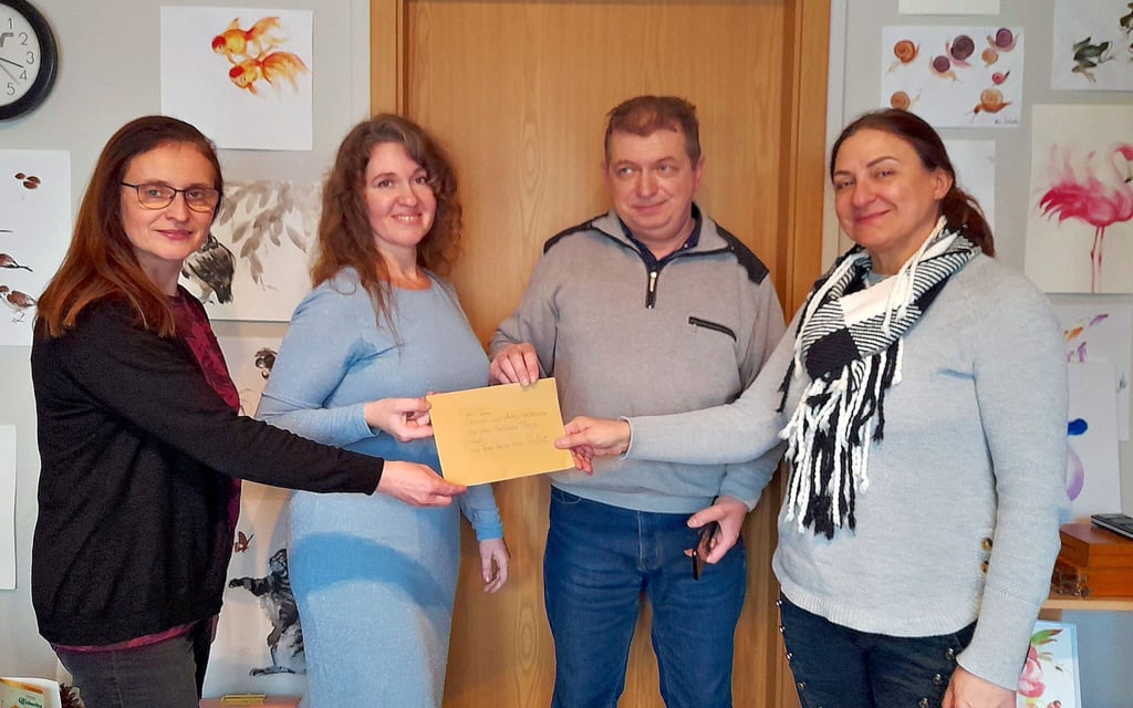 Eine Spende erhalten Eleonora und Andreji Shcherban (Mitte) von Künstlerin Swetlana Thiele (r.) aus einer Aktion der Partnerschaftsaktion Ost, vertreten durch Leiterin Rasa Hinz (l.).