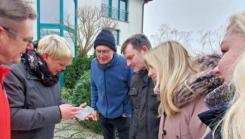 Jana Dießner-Kießling zeigt Frank Wallwitz (li.), Lisa Hoffmeister, Lucy und Marko Reiche und Martin Volk (v.re.) vor Zoumanes Wohnung Handyfotos.
