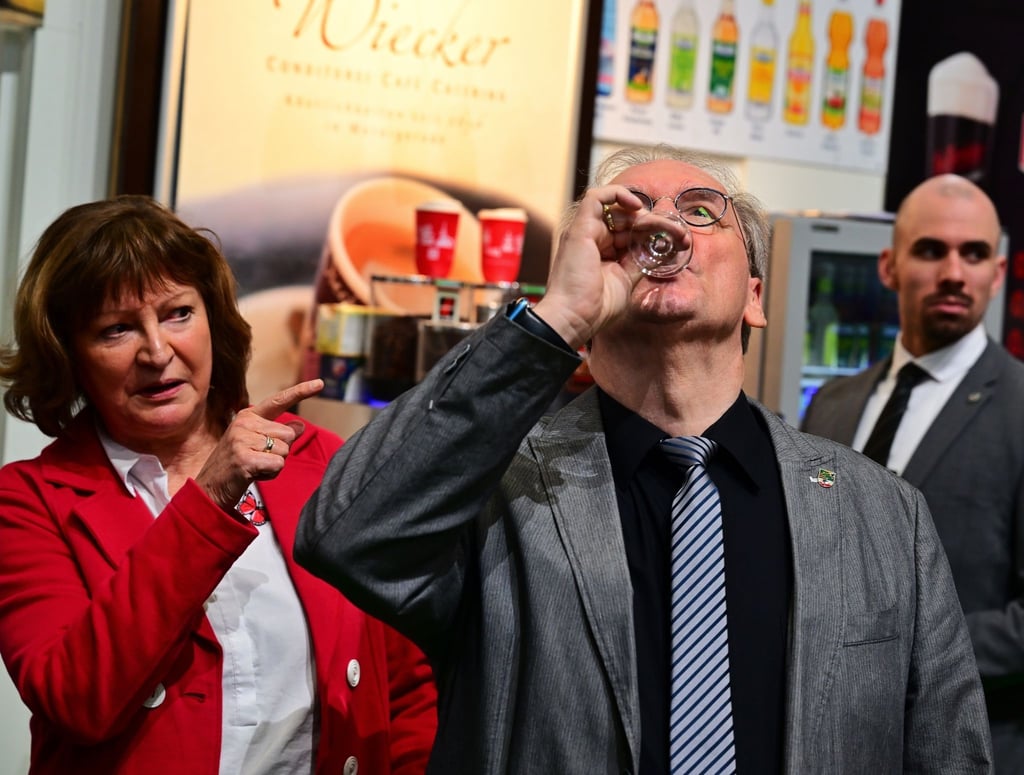 Reiner Haseloff (M) trinkt während der Internationalen Grünen Woche (IGW) am Stand der Fallstein Destillerie einen Gin.